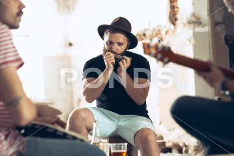 Repetition of rock music band. Electric guitar player and drummer behind the Stock Photos