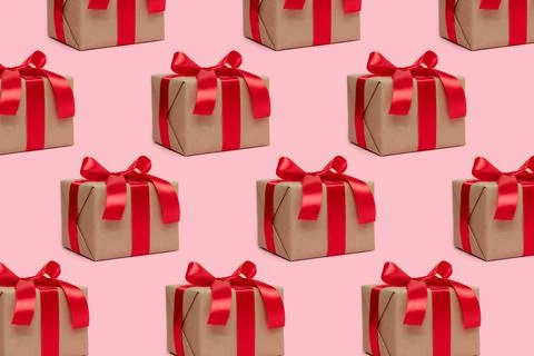 Repetitive pattern made of gift boxes tied with red ribbons. Stock Photos