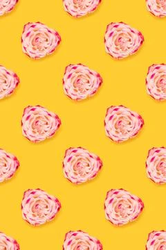 Repetitive pattern made of pink rose flower on a yellow bright background. Stock Photos