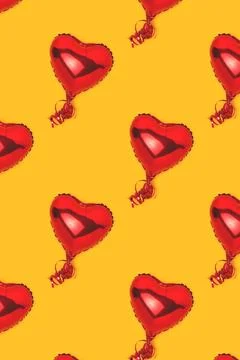 Repetitive pattern made of red inflatable foil balloons in a heart shape. 스톡 사진