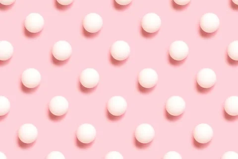 Repetitive pattern made white ping pong ball on a pink background. Stock Photos