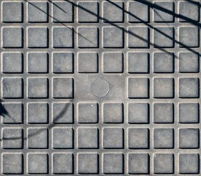 Repetitive pattern of square protrusions on a black rubber mat surface Stock Photos