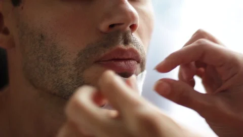 Replace the bandage on the wound on his face. Women's hands tear off the band Stock Footage 90911370
