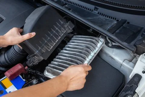 Replace old and dirty car air filters by hand. Fotos de archivo