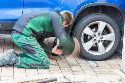 Replace summer tires against winter tires Intentional motion blur. Young M... Foto stock