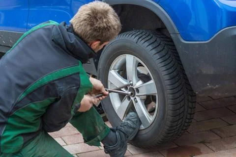 Replace summer tires against winter tires Young man exchanging the car tir... 스톡 사진