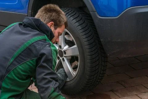 Replace summer tires against winter tires Young man exchanging the car tir... Foto stock