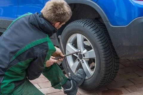 Replace summer tires against winter tires Young man exchanging the car tir... Foto stock