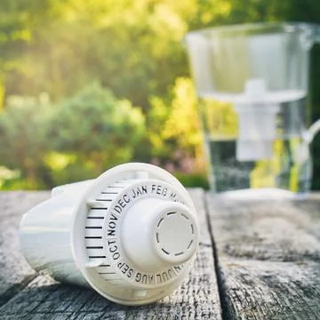 Replaceable cartridge and a water filter on the wooden table outdoors Foto stock