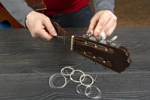 Replacement and insertion of nylon strings in a classical guitar. lesson for  Stock Photos