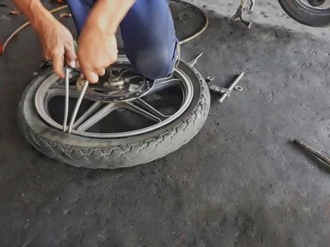 Replacement of the inner tire of a motorcycle wheel by a mechanic 스톡 사진