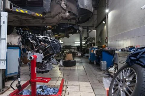 Replacement used engine mounted on a crane for installation on a car after a  Foto stock