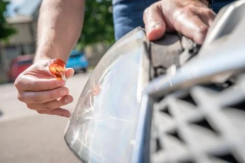 Replacement of the wrong bulb with a new one in the car headlight 스톡 사진