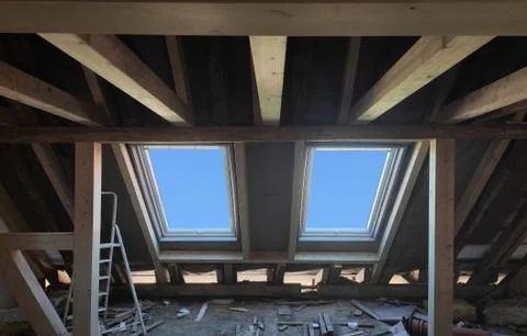 Replacing 2 plastic skylight windows in mansard attic of old house.Wooden beams Stock Photos