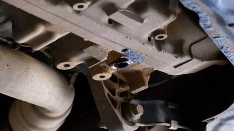 Replacing and draining old engine oil from the car. The old engine oil is poured Stock Photos