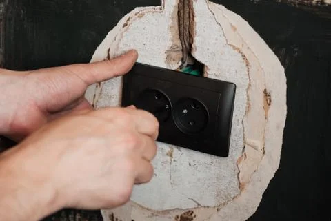 Replacing and installing a new electrical outlet. Hands with a screwdriver male Stock Photos