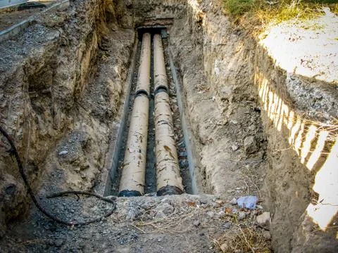 Replacing and insulating large water pipes in the ground. Stock Photos