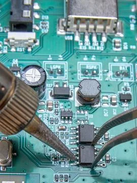 Replacing a damaged part in an electronic circuit board using a soldering iro Stock Photos