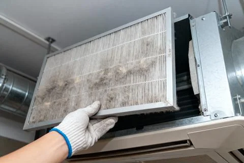 Replacing a dirty air filter in a ceiling-mounted HVAC system Stock Photos