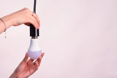 Replacing an energy-saving lamp with a lamp. Stock Photos