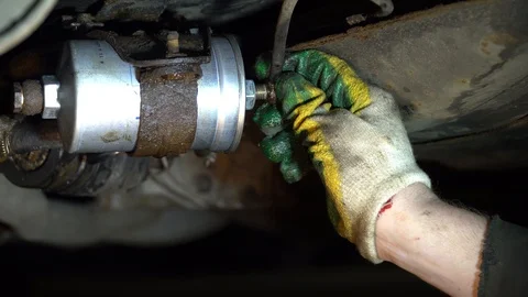 Replacing the fuel filter in the car. A station worker repairs a car. Stock Footage 121998796