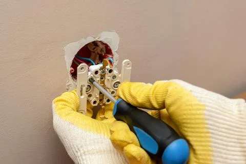 Replacing, installing an electrical socket, outlet with hands in protective r Foto stock