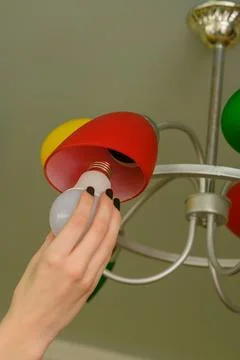 Replacing the LED light bulb in the lamp Stock Photos