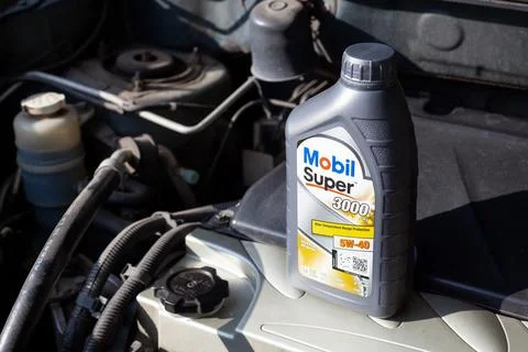 Replacing oil in car engine, close up. Mobil Super synthetic oil for engine. Stock Photos