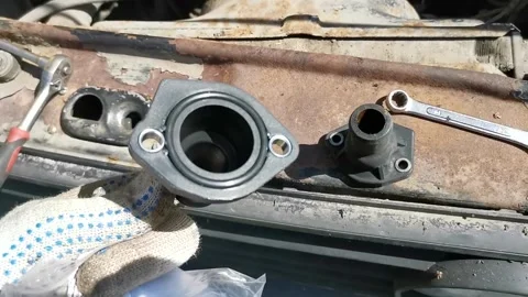 Replacing the old coolant flange with a new Stock Footage 296100493