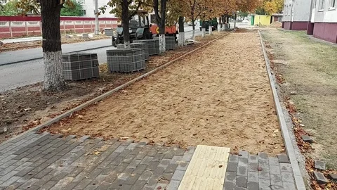 Replacing the old sidewalk road with cobblestones of cement. Pedestrian way with Stock-Footage 255635579