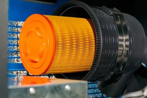 Replacing orange cylindrical air filter in industrial equipment 스톡 사진