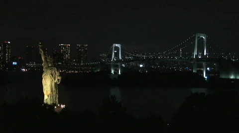Replica Statue of Liberty with the Rainbow Bridge behind it. Tokyo, Japan Stock Footage