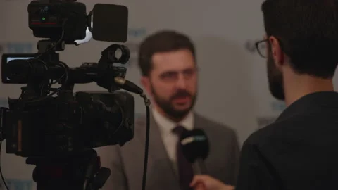The reporter asks the man being interviewed a question Stock Footage 228742030