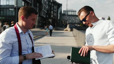 A reporter with his assistant prepares for an interview in the street Stock Footage 153245019