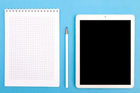Reporters book jotter with pencil and tablet pc copyspace. top view on blue b Stock Photos