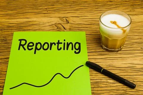 Reporting text on green paper with graph. Marker and coffee on desk. Stock Photos