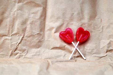 Representation of love through two red lollipops shaped like a red heart. Stock Photos