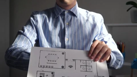 A representative of a designer or developer, builders, shows a floor plan Stock Footage 306543161