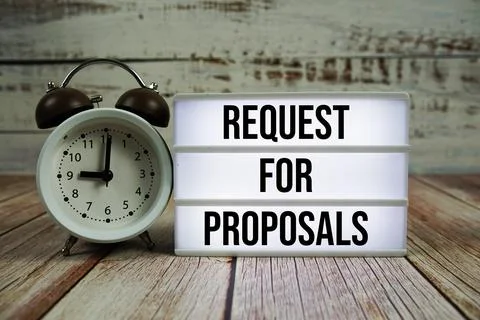 Request For Proposals text on light box with alarm clock on wooden background Stock Photos