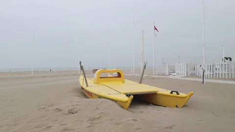 Rescue catamaran on sandy beach under cloudy winter sky Stock Footage 340358196