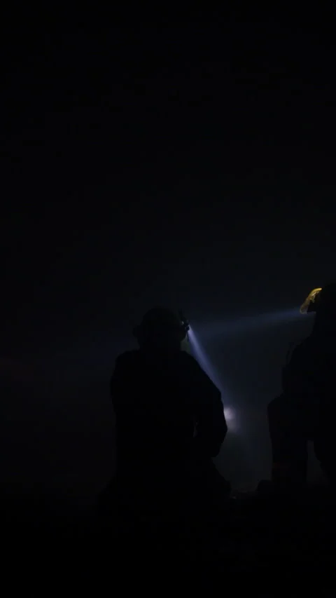 Rescue forces search for survivors inside a dark tunnel using flashlights Stock Footage 321187715