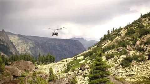 Rescue helicopter fly ower a high rocky mountain 库存影片 90258404