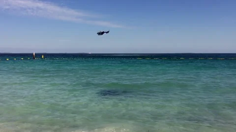 Rescue helicopter hovers low over ocean then flies off Stock Footage 242065663