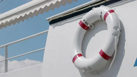 Rescue ring with red warning colors on white ship railing in front of sky Stock Footage 155028312