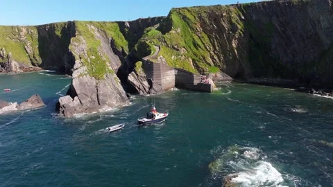 Rescue Vessel Approaches Pier with Dramatic Cliffs in Background Vídeos de archivo 337036617