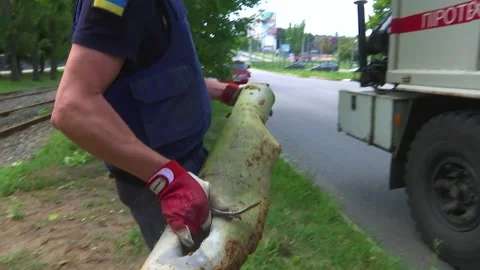 The rescuer carries an exploded metal shell into the car. Real war, Russia Stock Footage 208408558