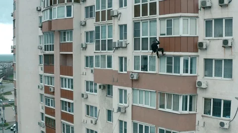 The rescuer climber descends, using a rope on the facade of a multi-storey Stock Footage 105159935