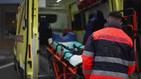 Rescuer getting empty stretcher inside ambulance vehicle. Stock Footage 233444888