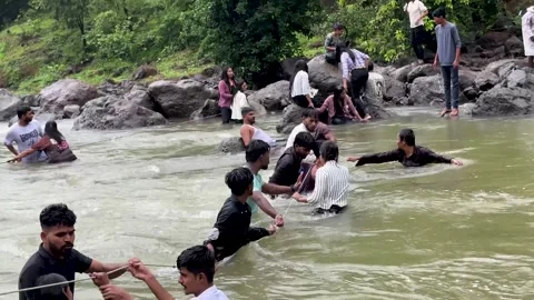Rescuers forming a human chain to help people cross a river 4K Video 動画素材 340251837