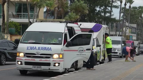 Rescuers pull drowning man from Karon beach. Ambulance awaits patient Stock Footage 305126741